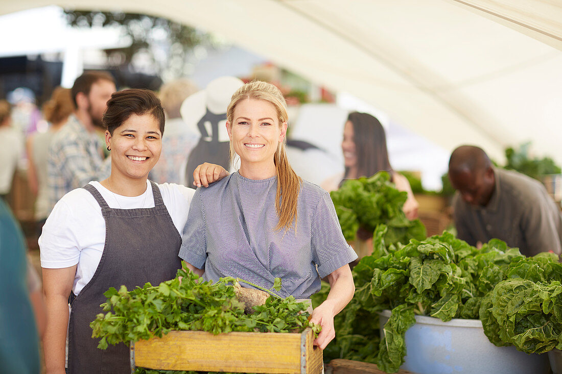 Women workers with crate of vegetables at farmer's market