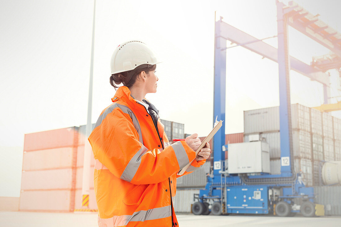 Female dock manager watching cargo containers
