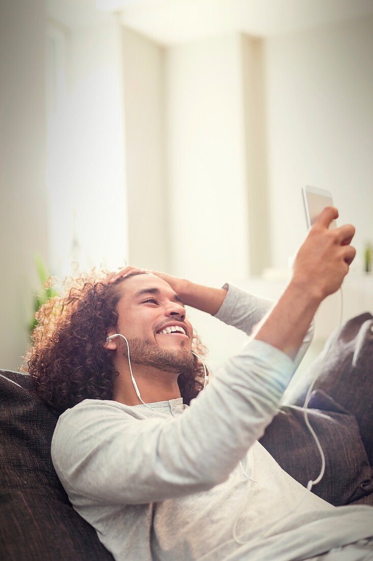 Smiling man listening to music with headphones