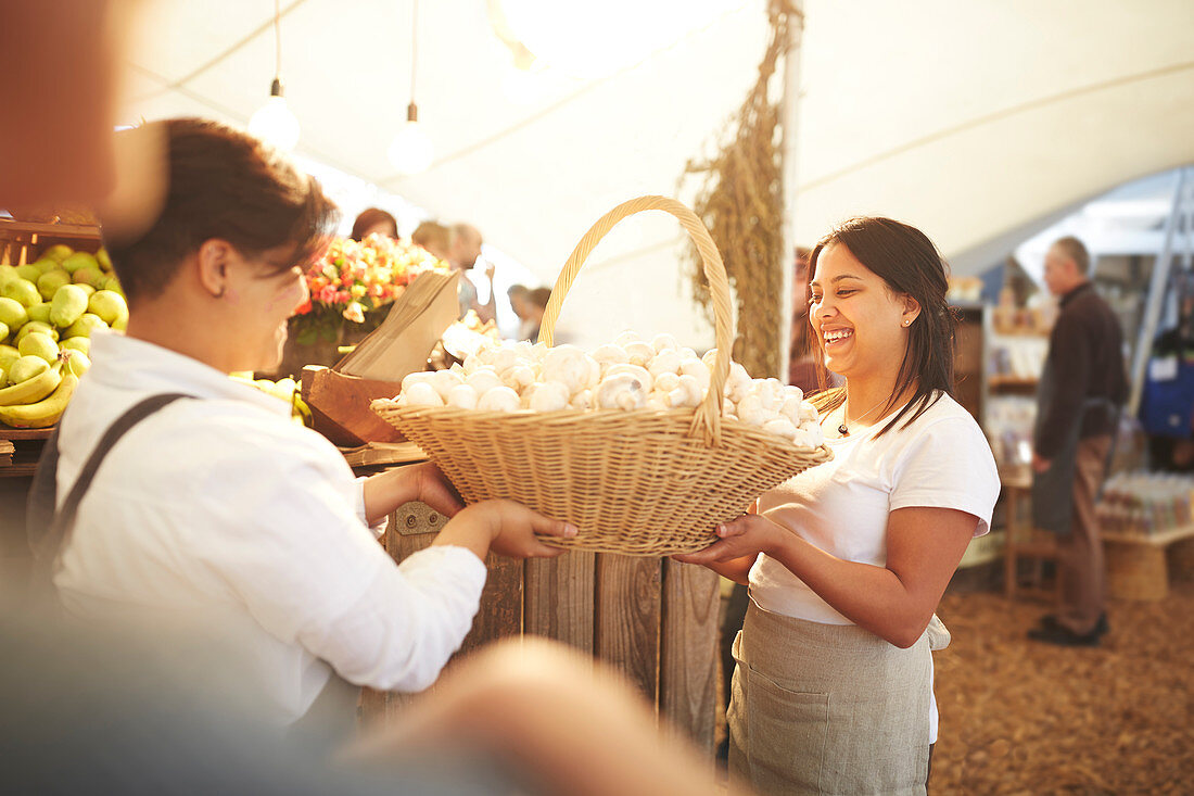 Women carrying basket of fresh garlic at farmer's market
