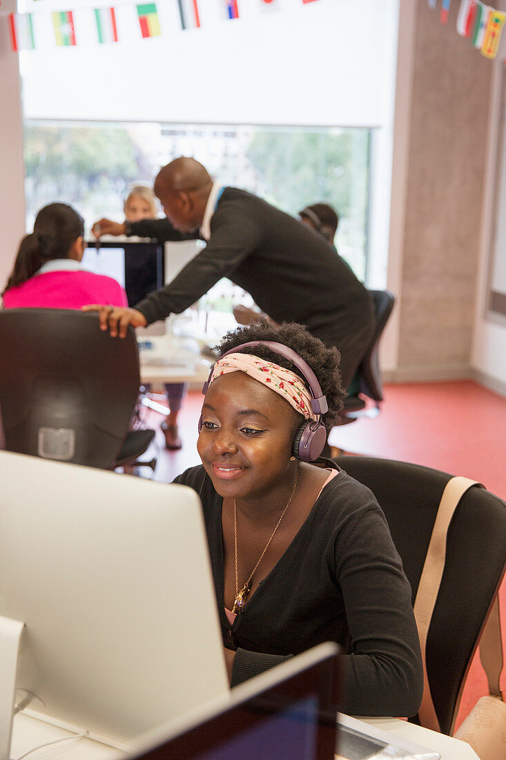 Female student with headphones at computer