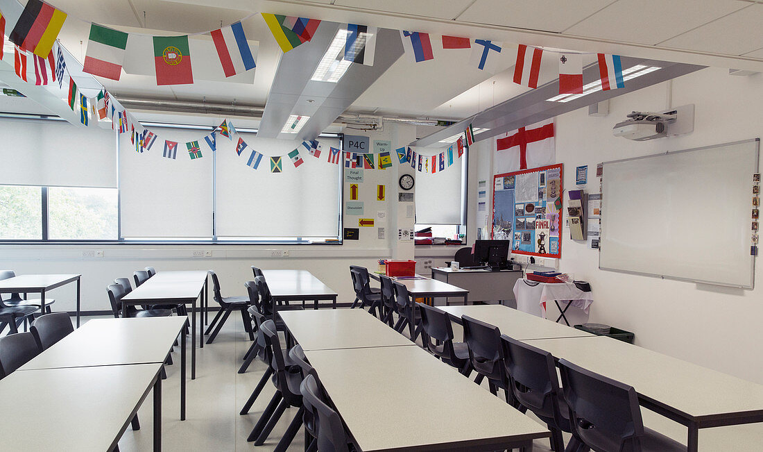 National flags hanging above tables in classroom