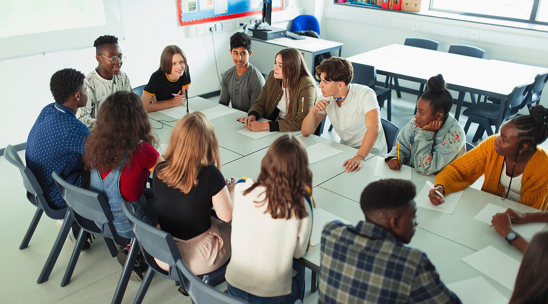 High school students talking at table in debate class