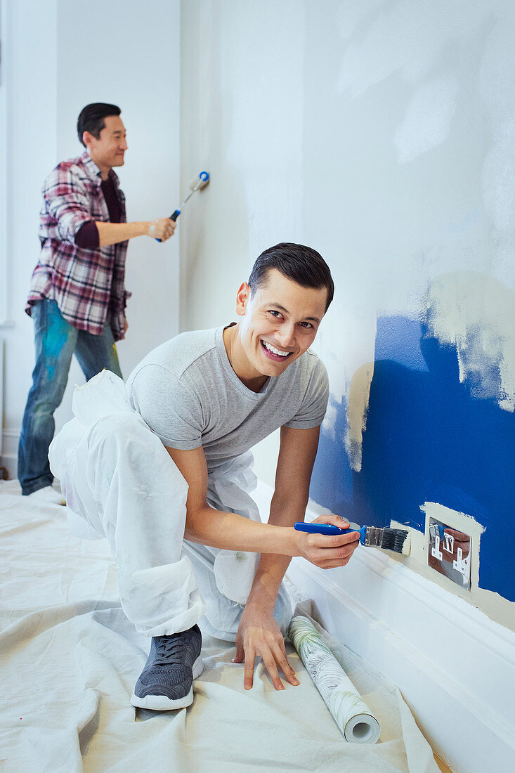 Portrait happy man painting wall