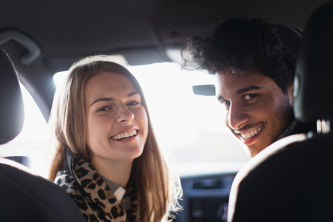 Portrait happy young couple in car