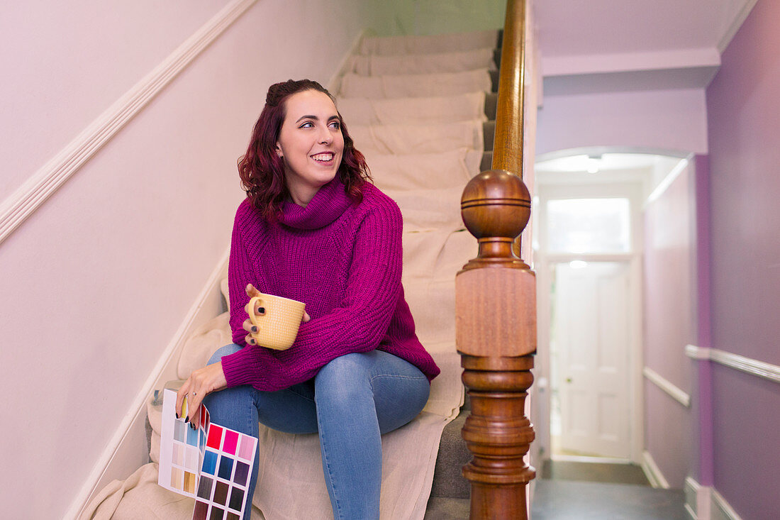 Woman with paint swatches redecorating on stairs