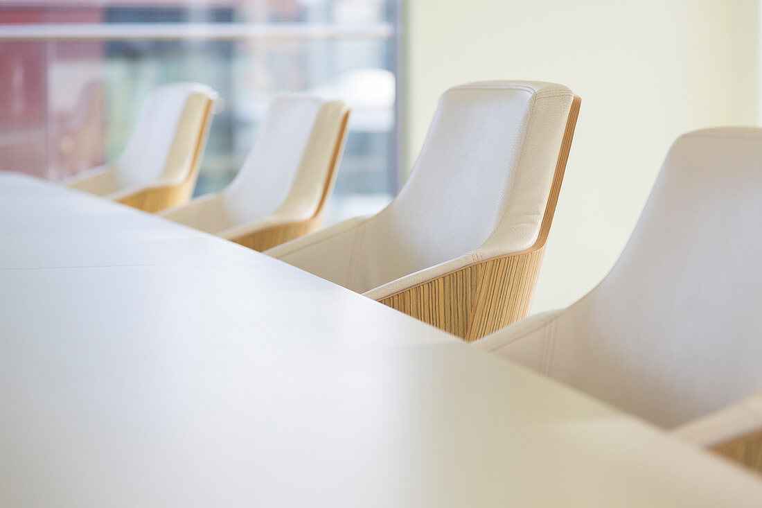 White leather armchairs in a row in conference room