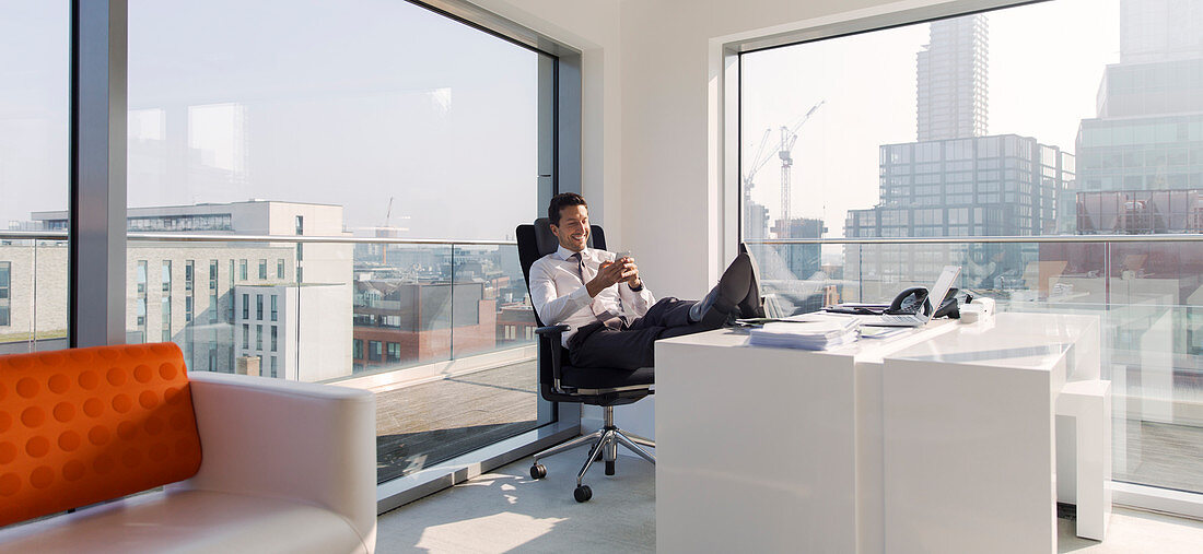 Businessman with feet up on desk