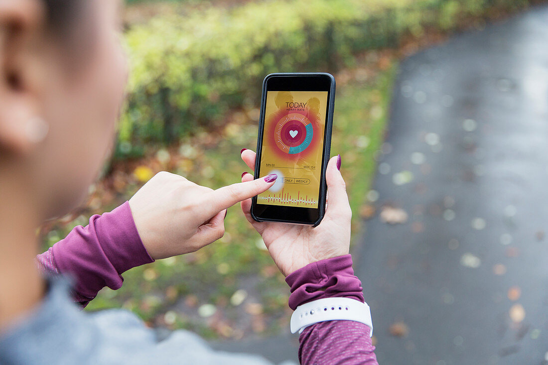 Female runner checking heart rate monitor