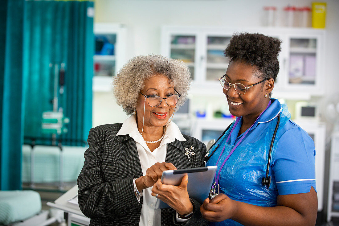 Female doctor and nurse using digital tablet in hospital