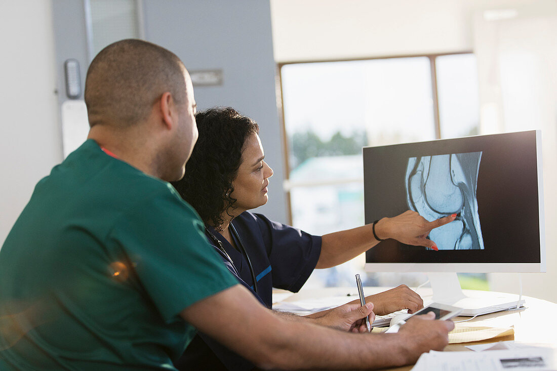 Nurses discussing digital x-ray at computer in clinic