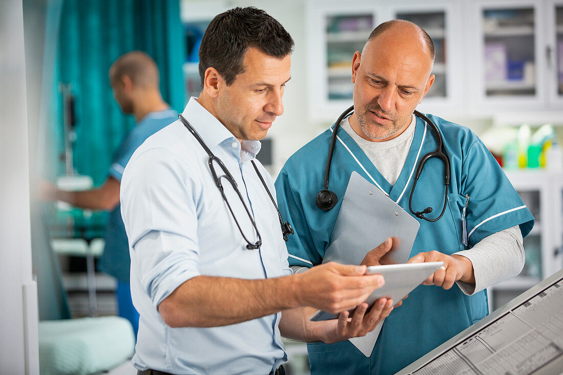 Male doctors using digital tablet in hospital