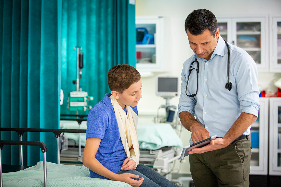Paediatrician showing tablet to boy patient
