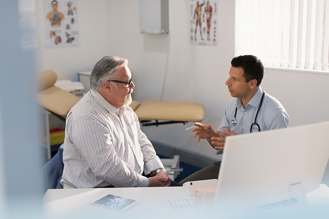 Male doctor talking with patient in doctors office