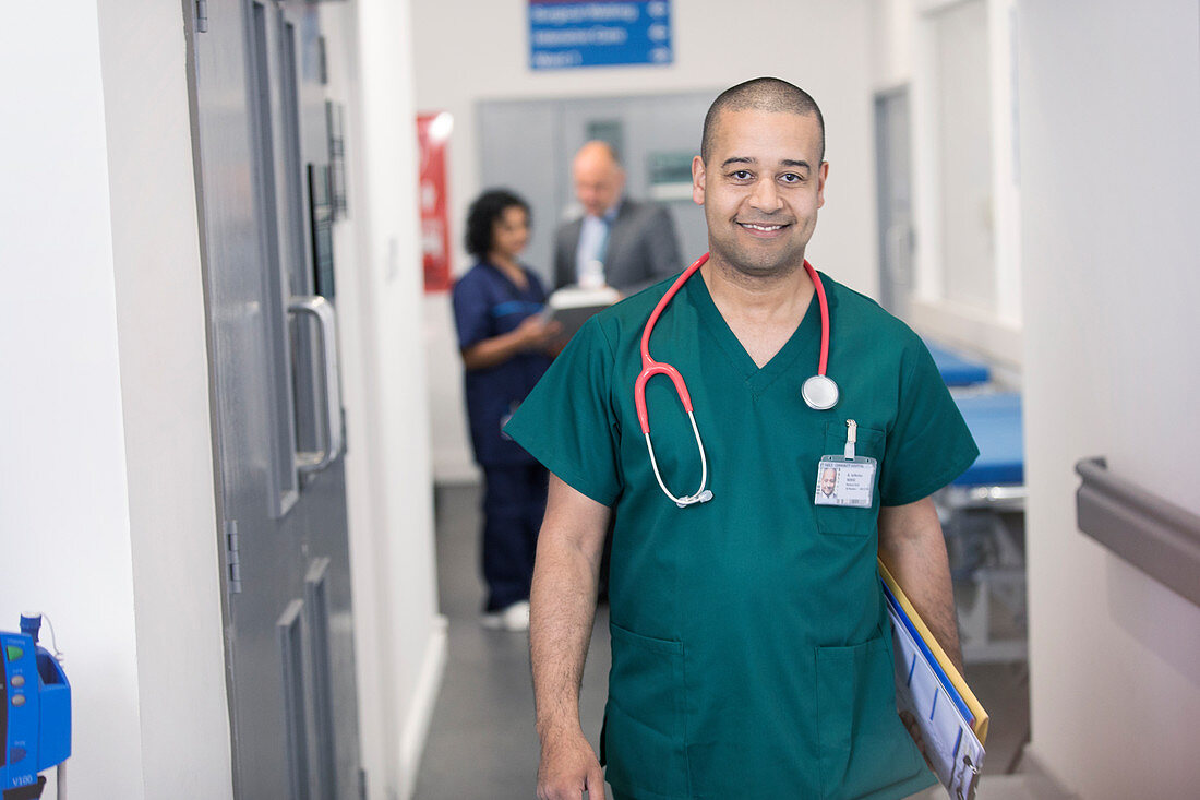 Portrait male surgeon walking in hospital corridor