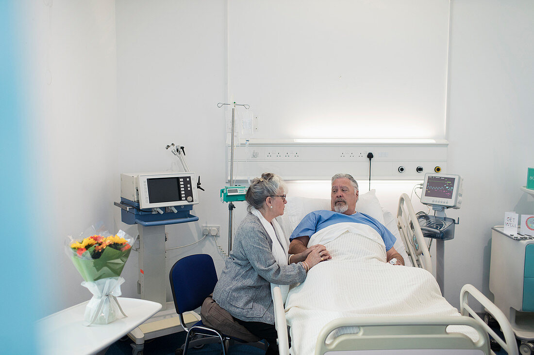 Senior woman visiting, comforting husband resting