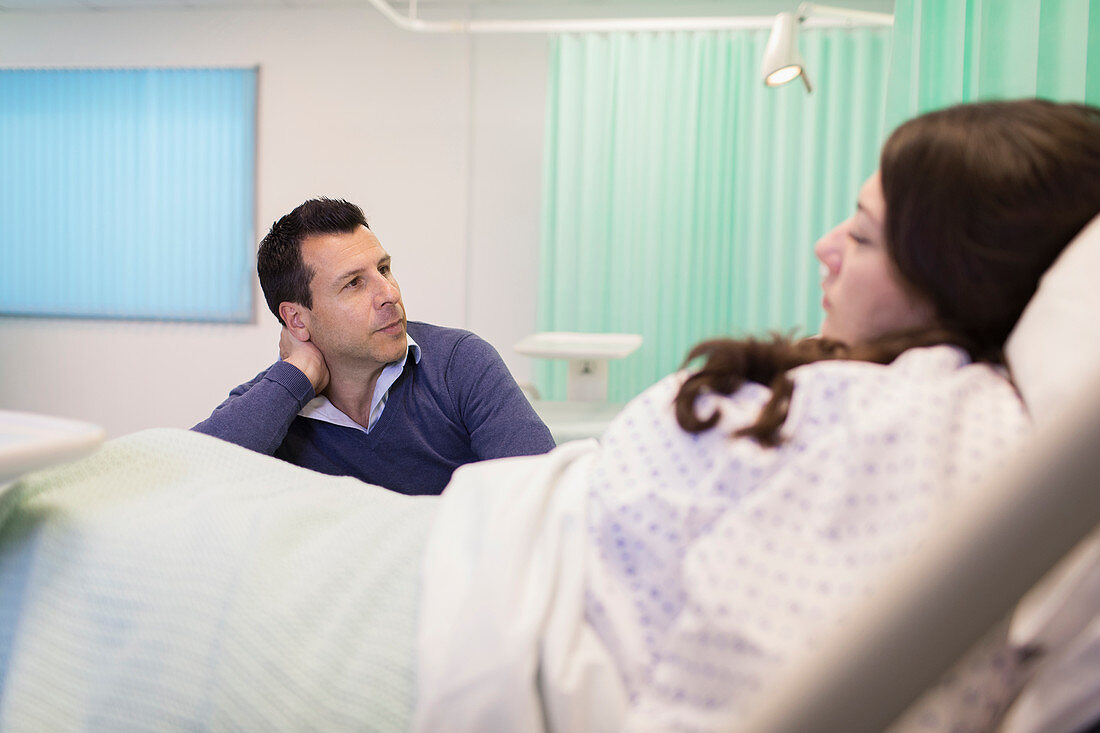 Man visiting wife resting in hospital bed