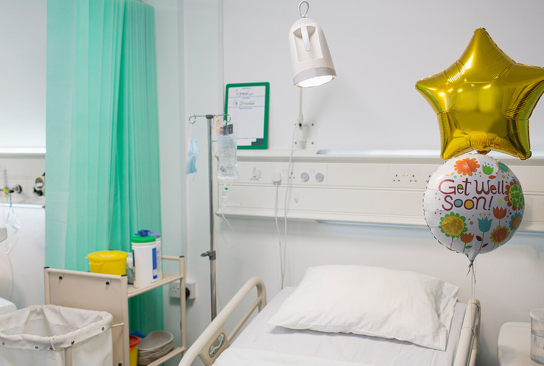 Get Well balloons tied to bed in vacant hospital room