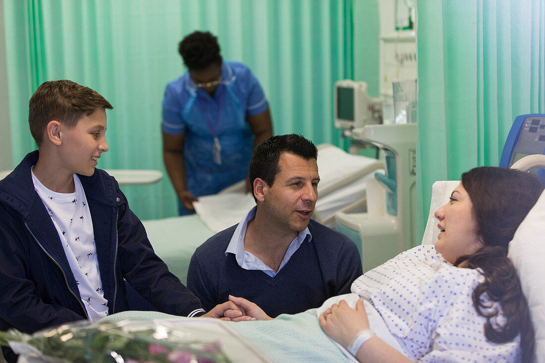 Family visiting, talking with patient in hospital ward