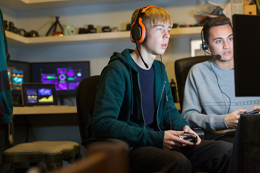 Boys with headphones playing video game
