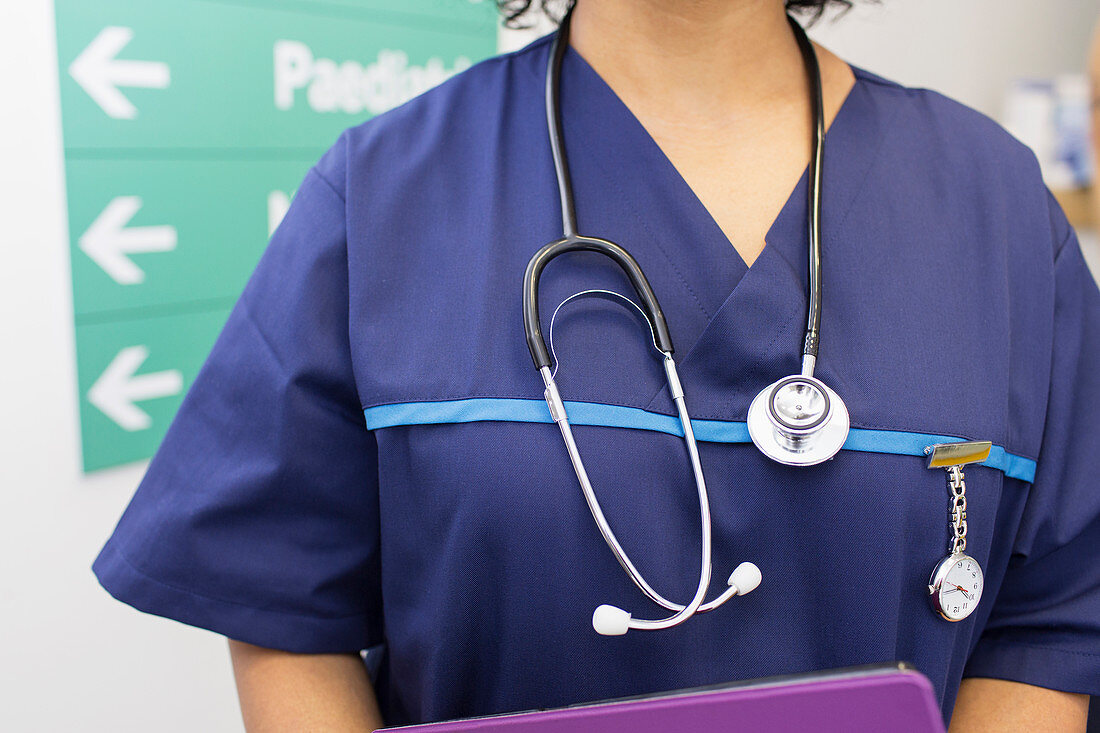 Close up doctor wearing scrubs and stethoscope in hospital
