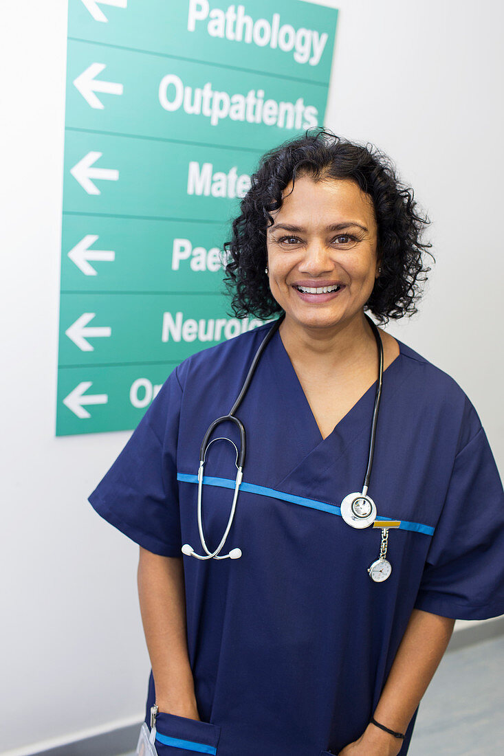 Portrait confident, doctor in hospital corridor