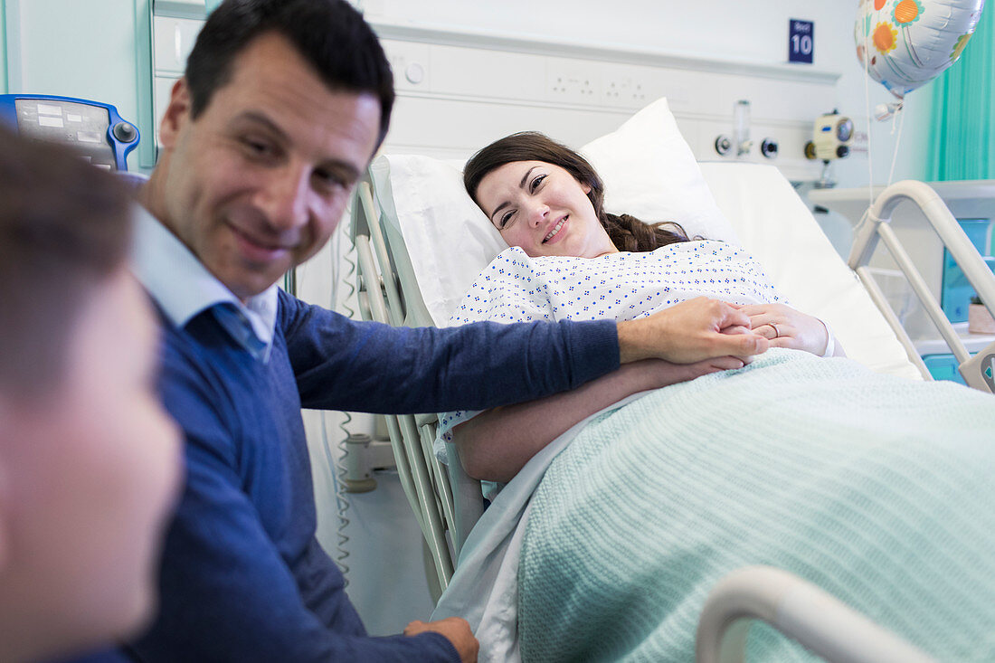 Affectionate family visiting patient in hospital room