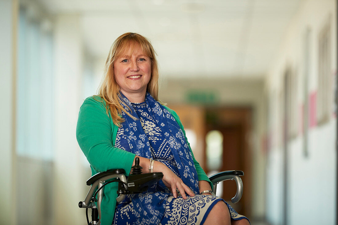 Portrait woman in wheelchair in corridor