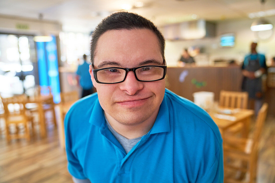 Close up portrait young man with Down Syndrome in cafe