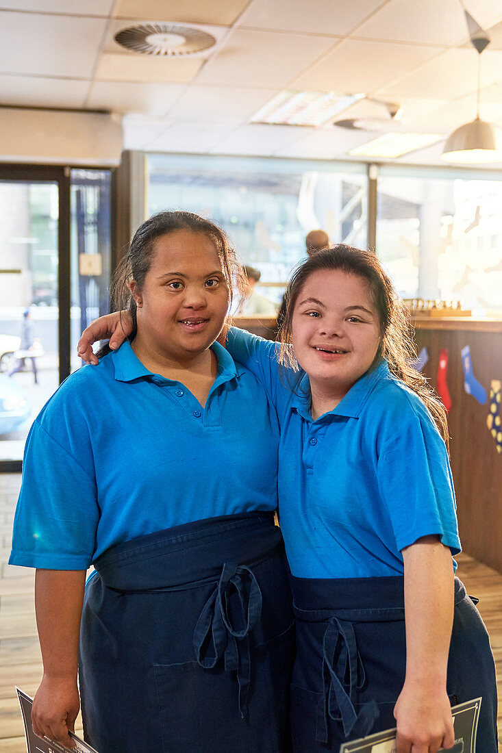 Portrait young women with Down Syndrome working in cafe