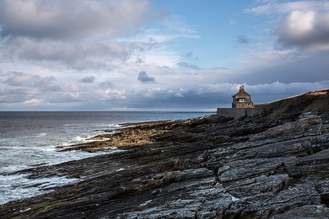 House overlooking rocky seascape Howick Northumberland UK