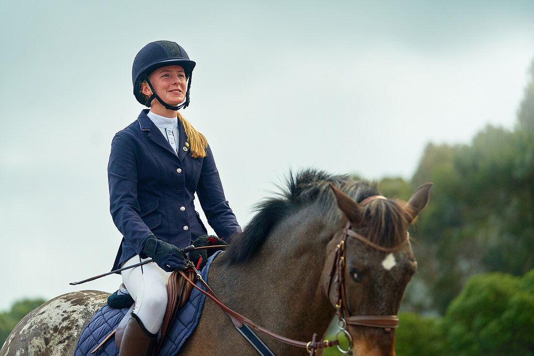Confident teenage girl equestrian horseback riding