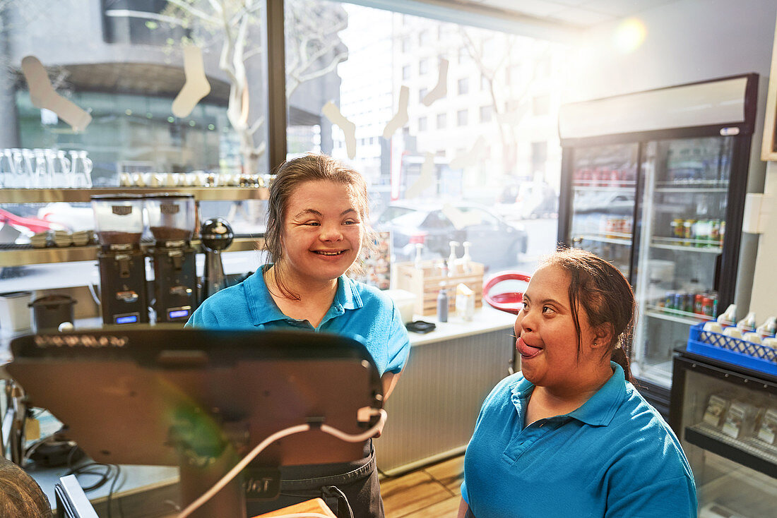 Happy young women with Down Syndrome working in cafe