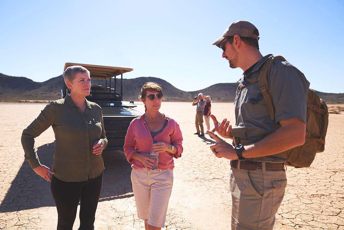 Guide talking with women in sunny desert South Africa