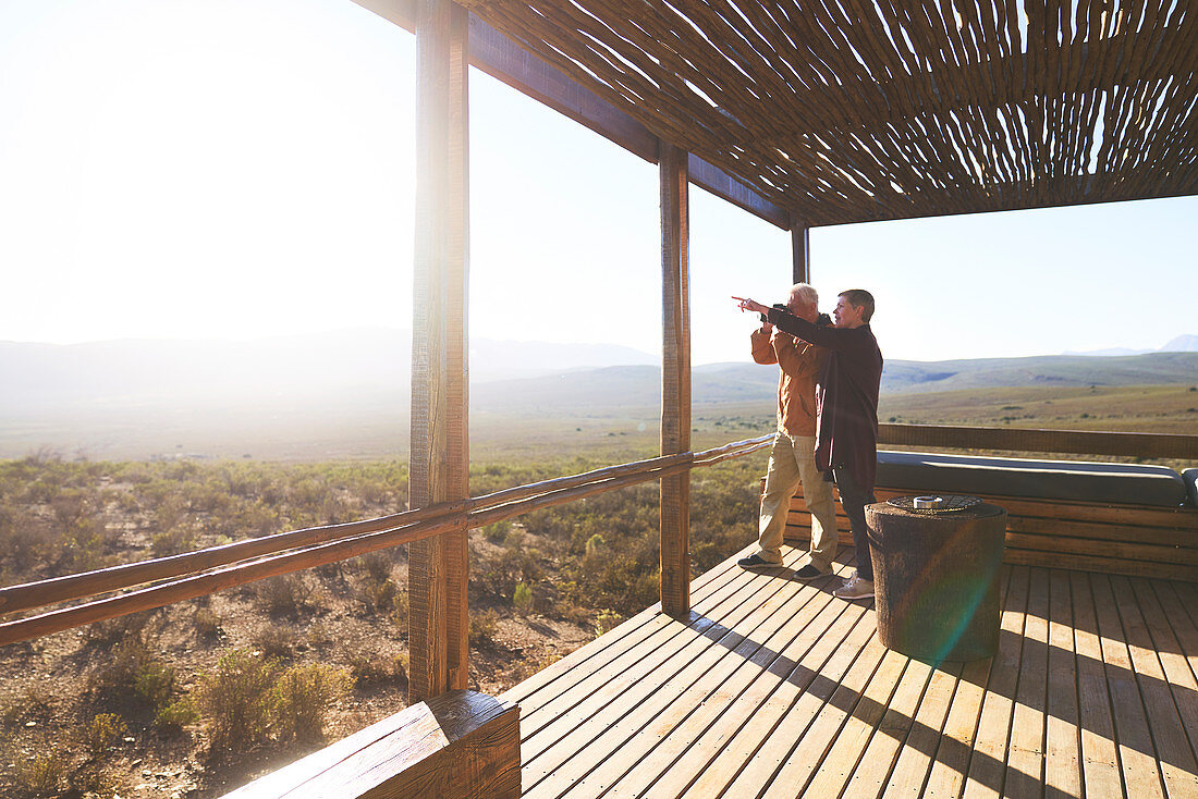 Senior couple looking at view from safari lodge balcony