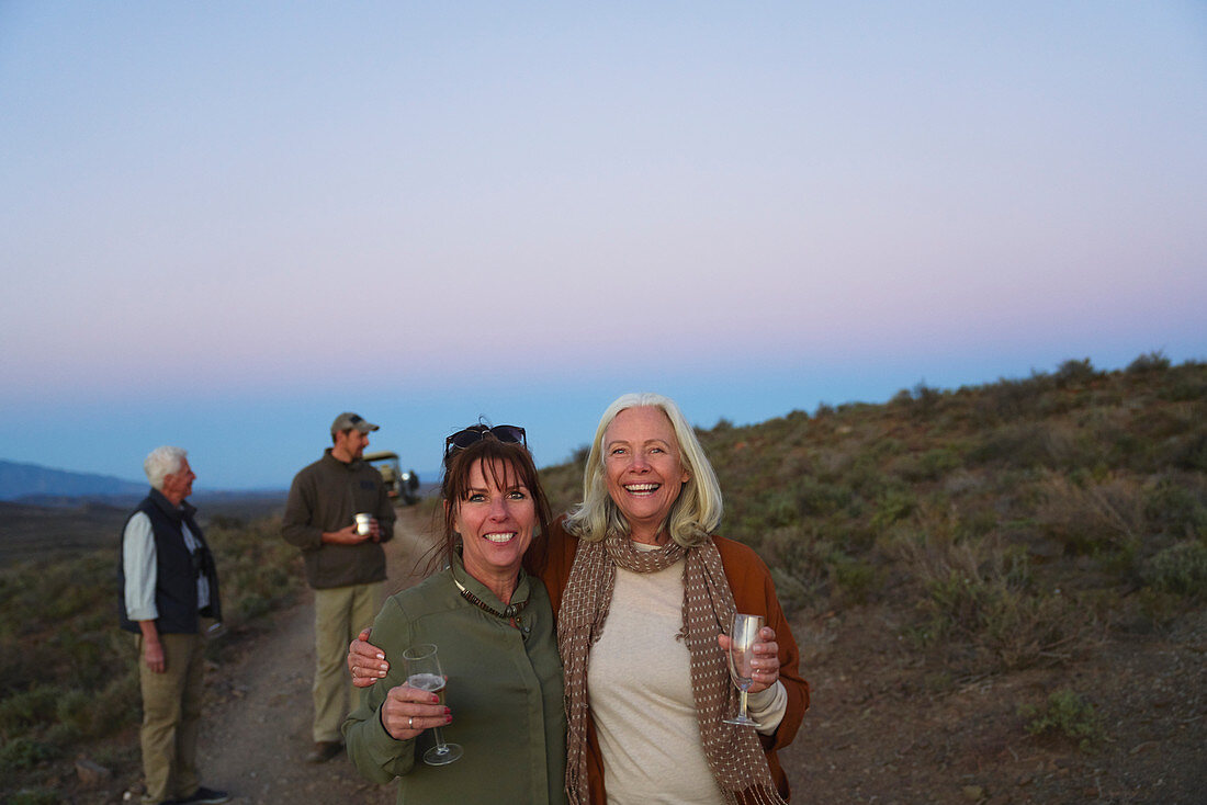 Mature women friends on safari drinking champagne