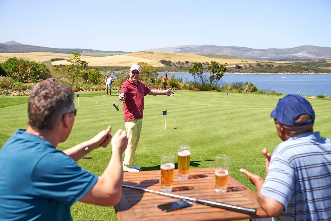 Happy golfers drinking beer and practicing