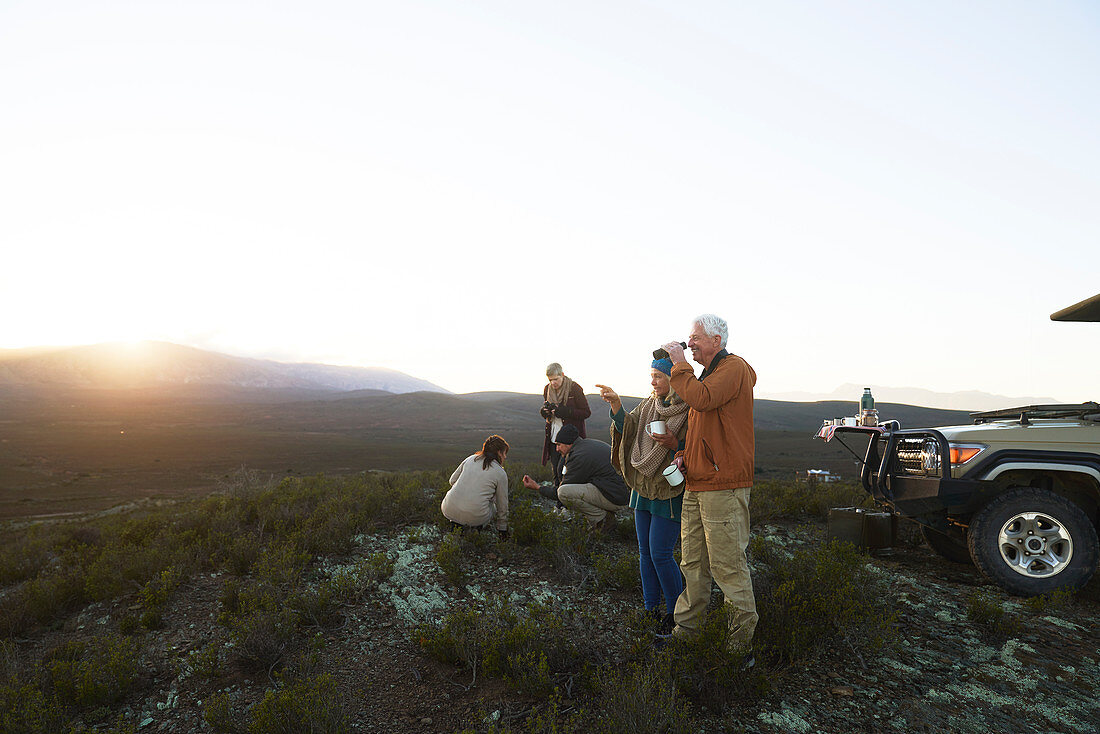 Group drinking tea and enjoying sunrise landscape view