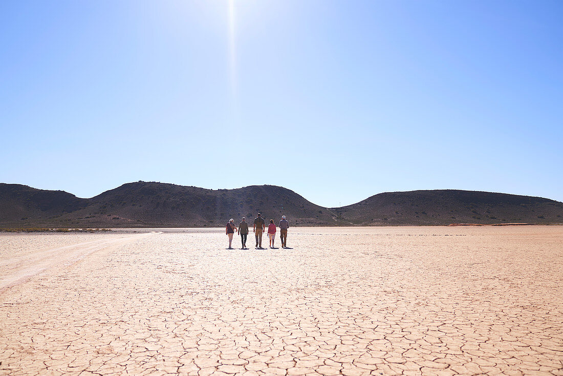 Group walking along sunny cracked earth South Africa