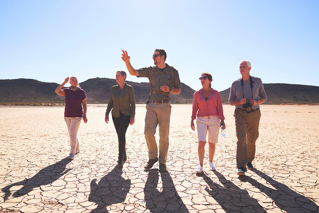 Guide leading group in sunny arid desert South Africa