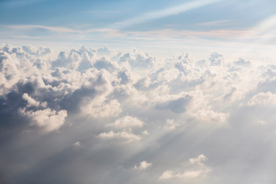 Aerial view sunbeams over fluffy white clouds