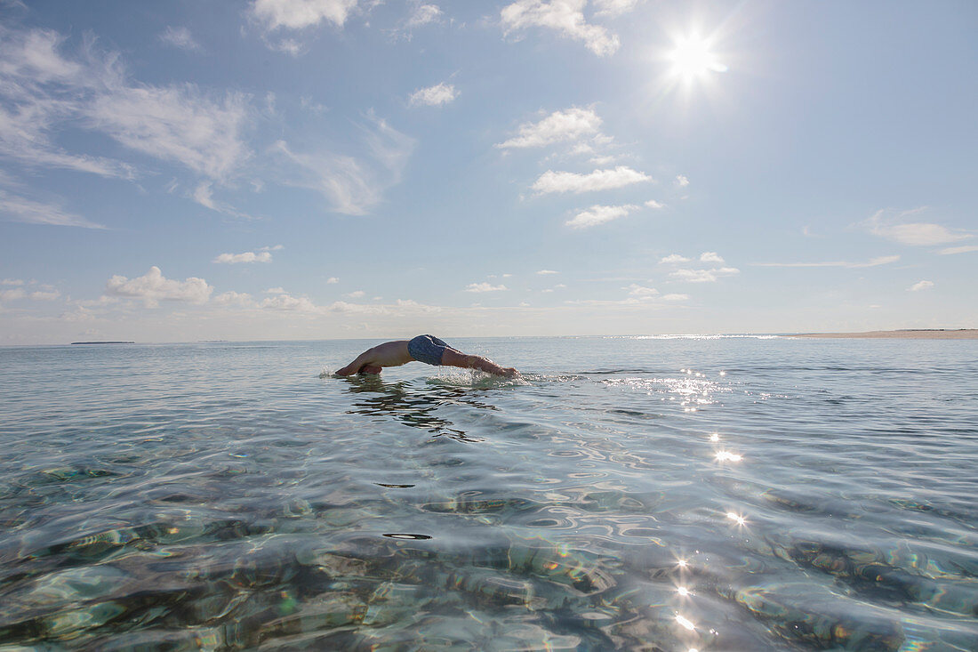 Man diving in sunny, idyllic ocean, Maldives