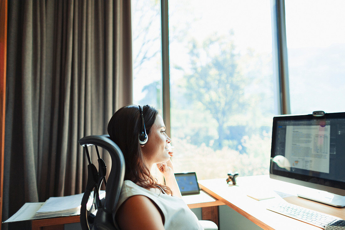 Businesswoman with headset working in home office