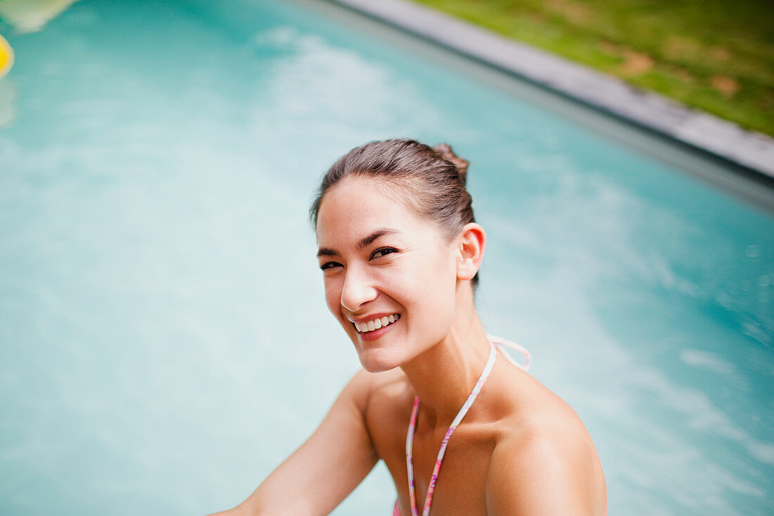 Portrait happy, laughing woman at swimming pool