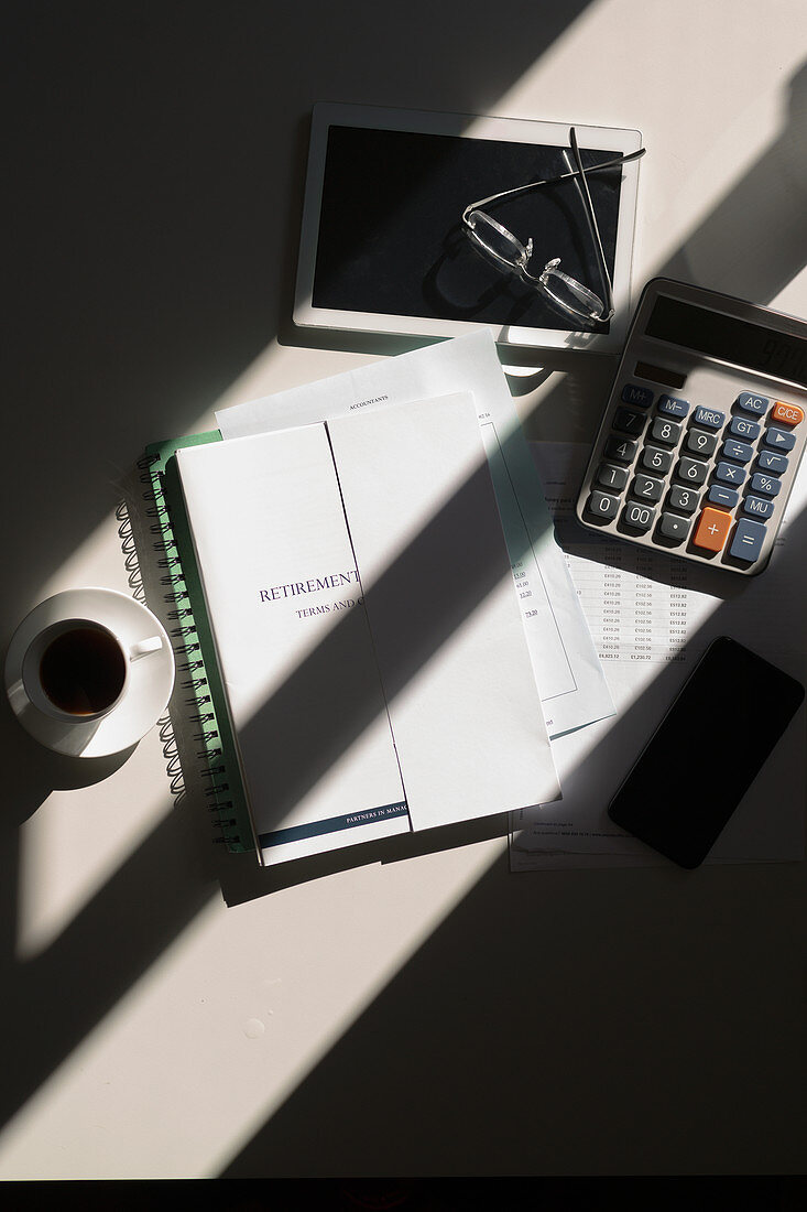 Retirement portfolio on table with calculator and coffee
