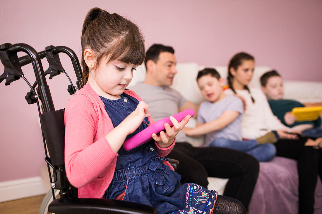Girl using digital tablet in wheelchair