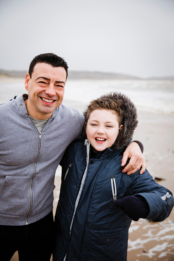 Portrait happy father and son on beach