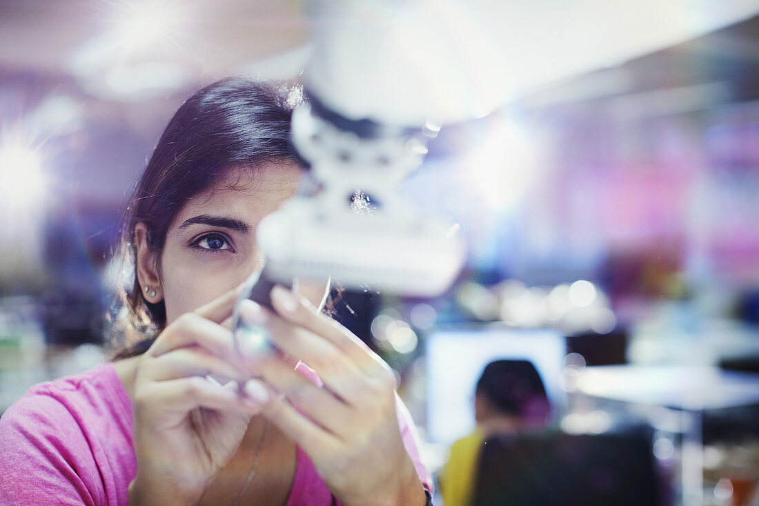 Focused female engineer repairing robotic arm