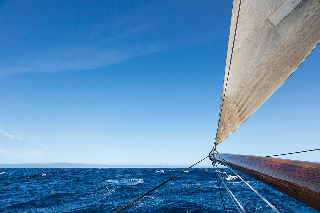 Wooden sailboat mast over blue Atlantic Ocean