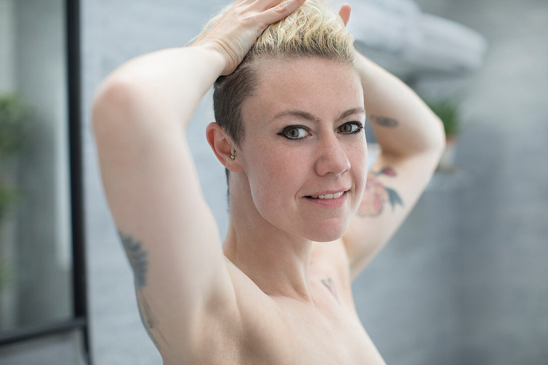 Portrait beautiful woman with tattoos in bathroom